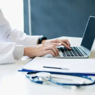 Female doctor operating laptop